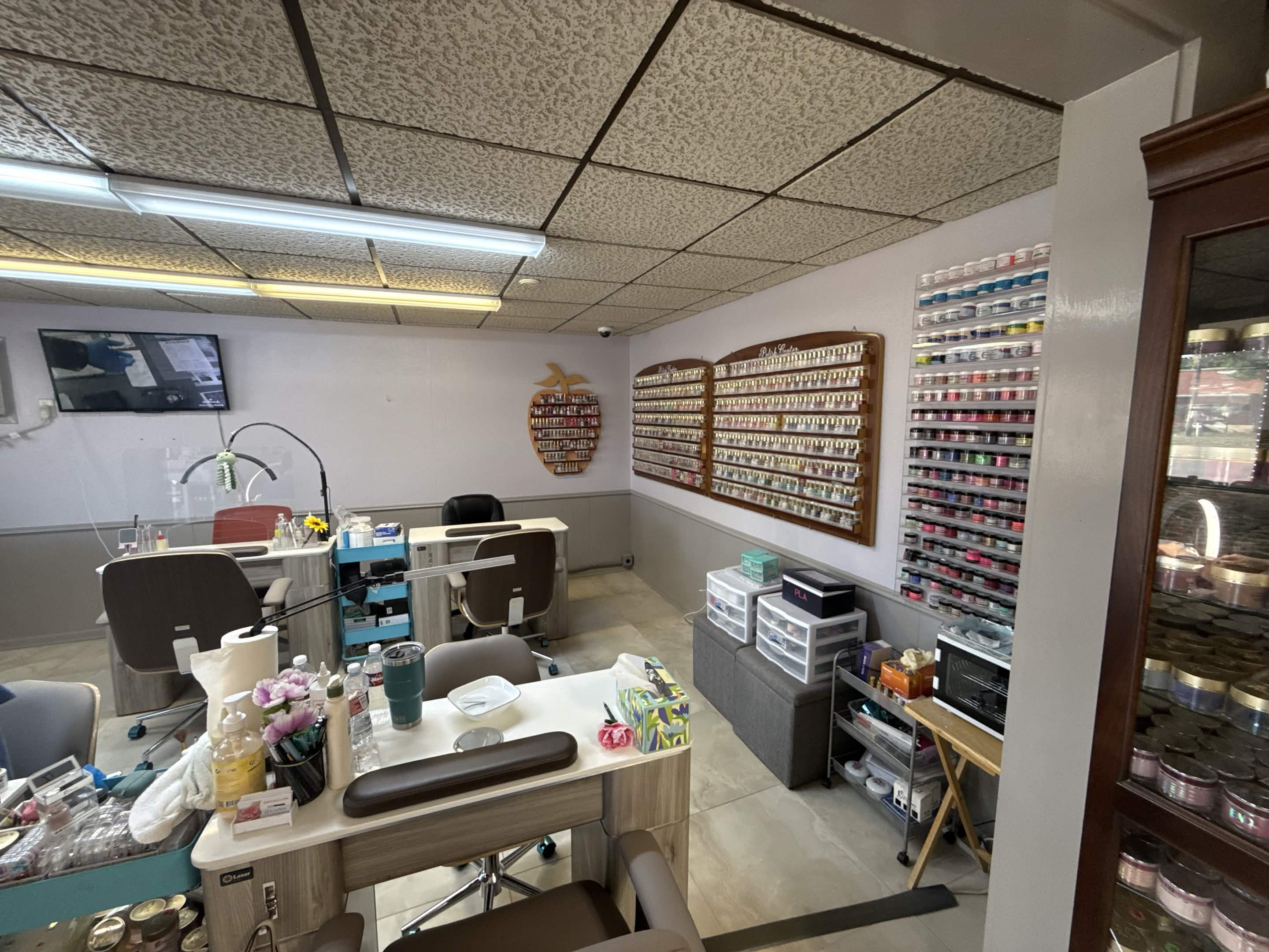 Manicure stations and nail color wall at Kim's Nail & Spa